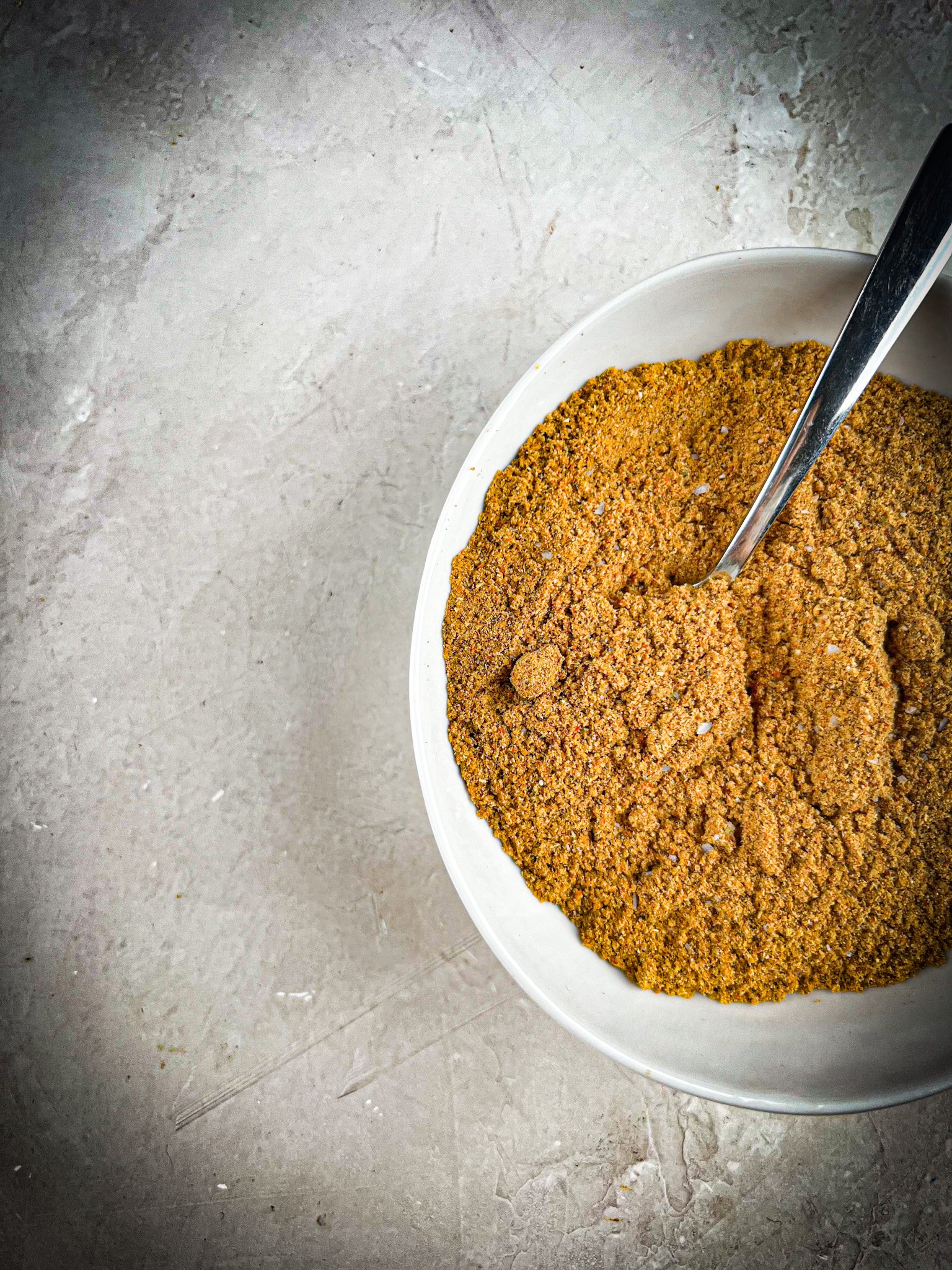 in a bowl of chaat masala with a spoon dig in the chaat masala.